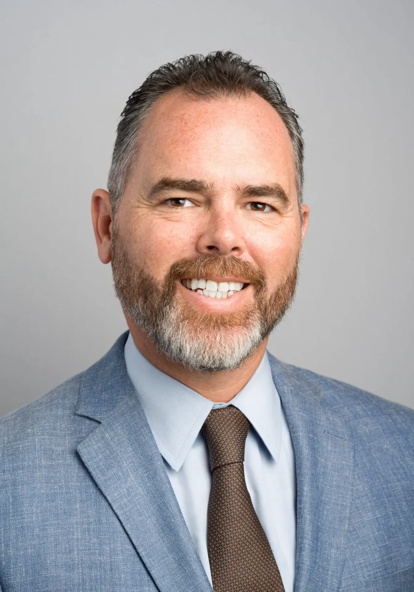 Professional man in a suit smiling at the camera.