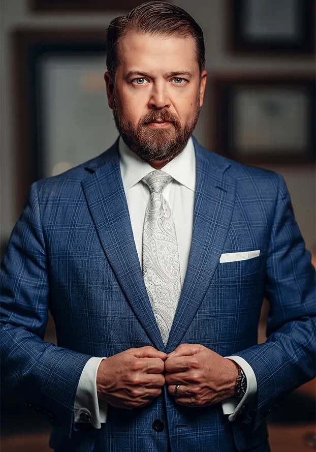 Man adjusting his blue suit jacket confidently.